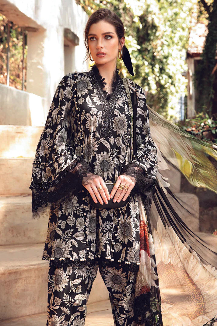 Woman wearing a black and white floral embroidered outfit with a dupatta in an outdoor setting.