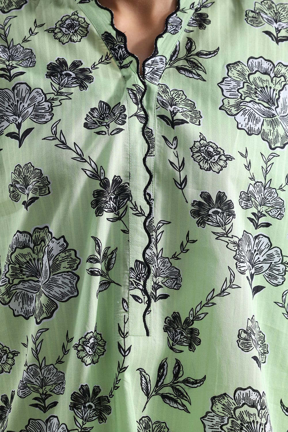 Green fabric with black floral pattern