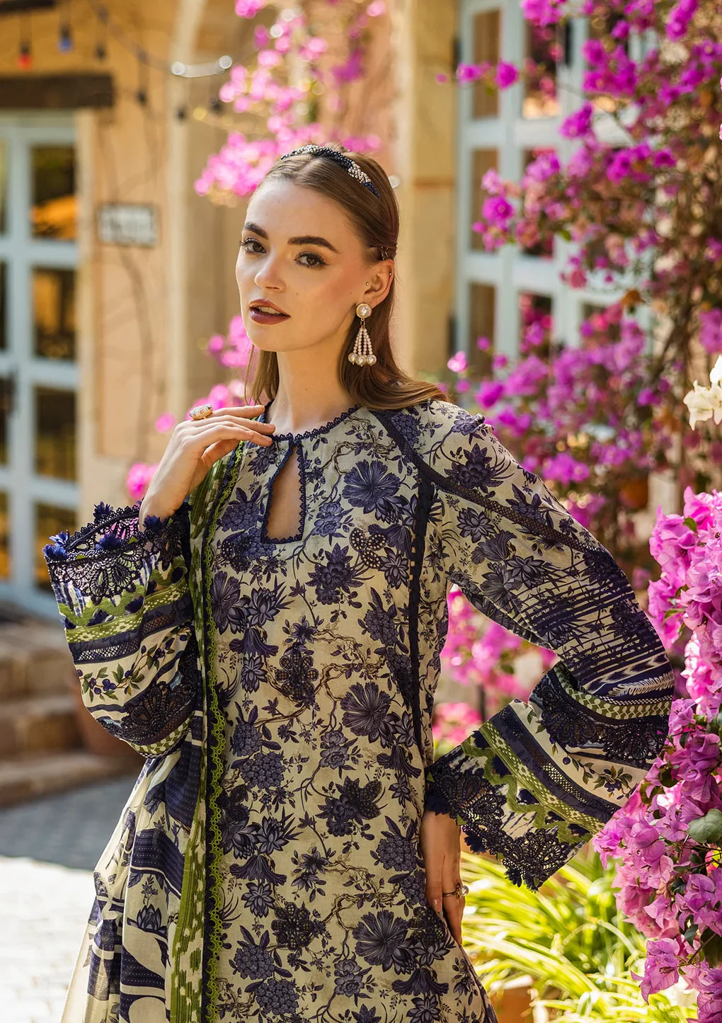 Woman in a floral dress standing in front of pink flowers