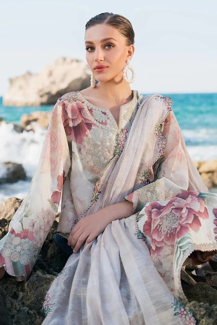 Woman in a floral outfit sitting on rocks by the ocean