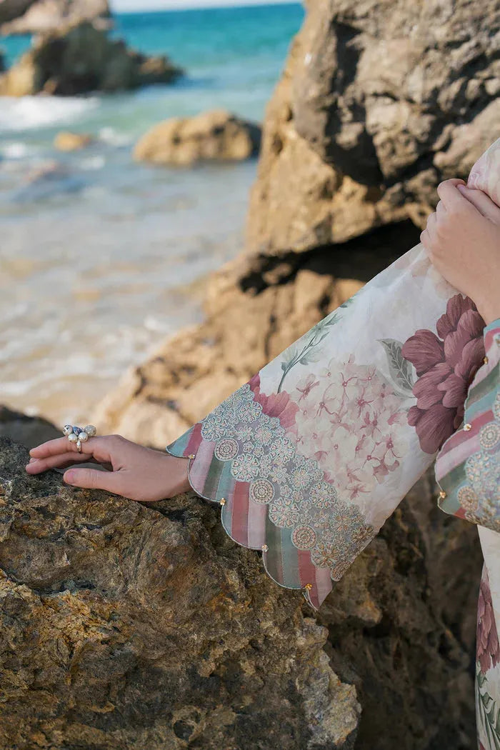 Person wearing a floral dress by the sea with rocks and water in the background