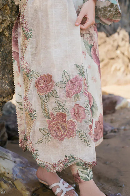 Person wearing a floral embroidered dress standing on a beach.