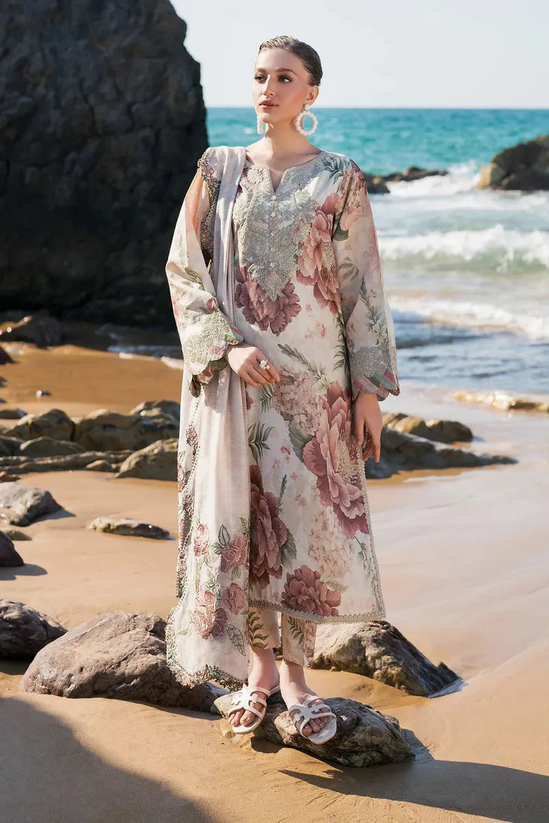 Woman in a floral dress standing on a rocky beach with ocean in the background