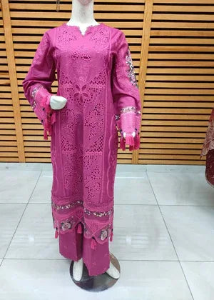 Mannequin wearing a pink traditional outfit with embroidery against a wooden panel background