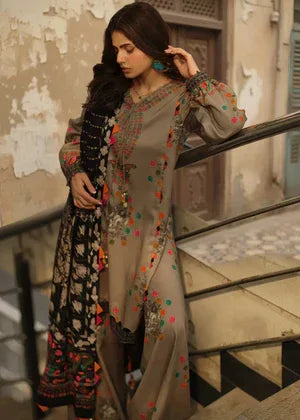 Woman in traditional outfit with intricate patterns standing on a staircase.