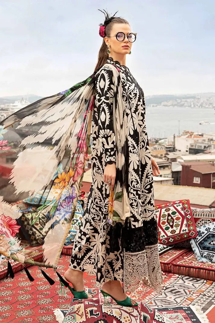 Woman in a patterned outfit with a colorful scarf on a rooftop with cityscape view