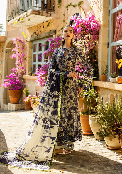 Woman in a floral dress standing in front of a building with flowers and plants.