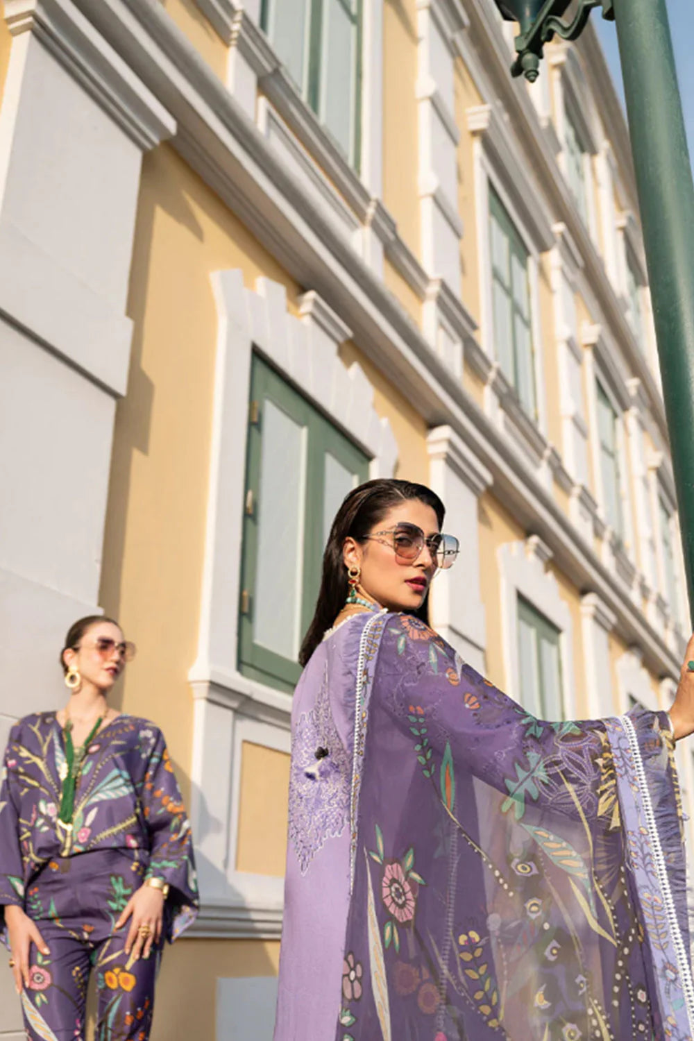 Woman in a purple outfit standing in front of a building