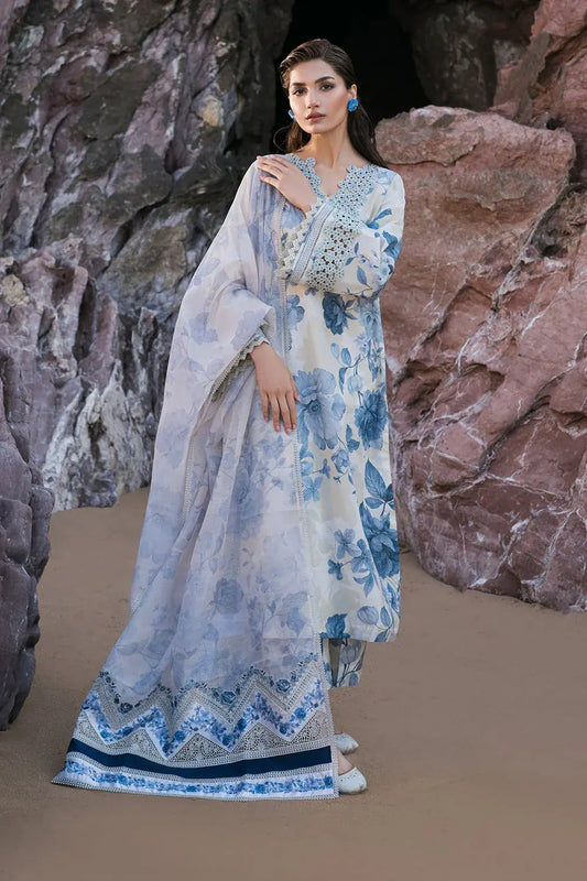 Woman in a floral dress standing against a rocky background