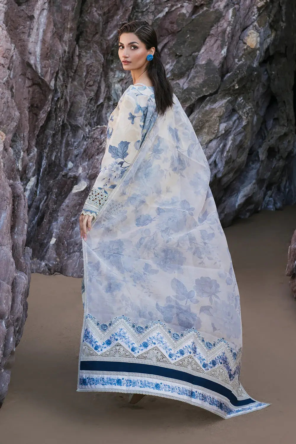 Woman wearing a floral dress with a stone wall background