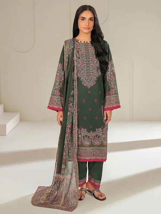 Woman wearing a green embroidered traditional outfit with a matching dupatta in a minimalistic setting.