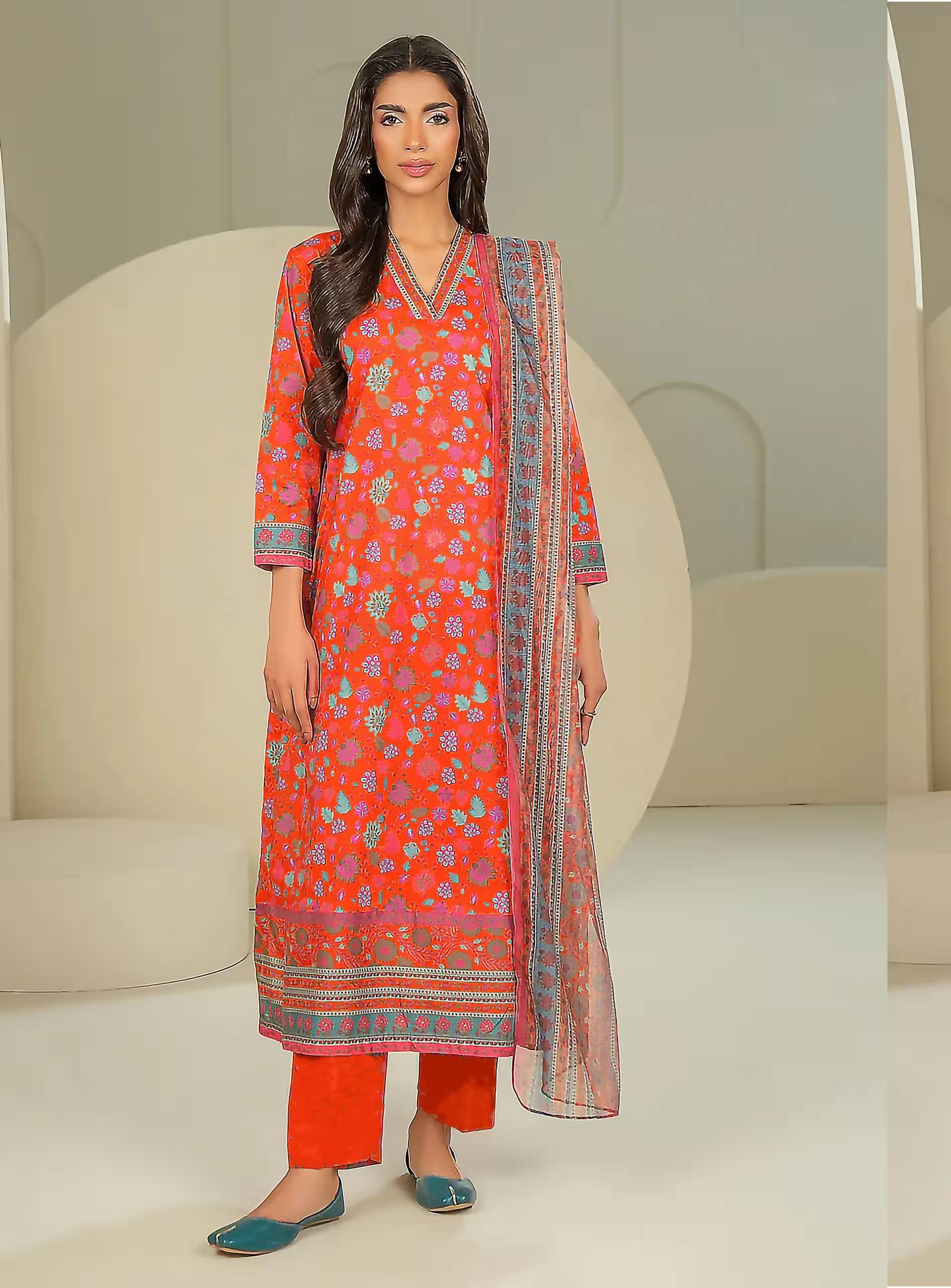 Woman wearing a red floral dress with a matching dupatta in a minimalistic setting