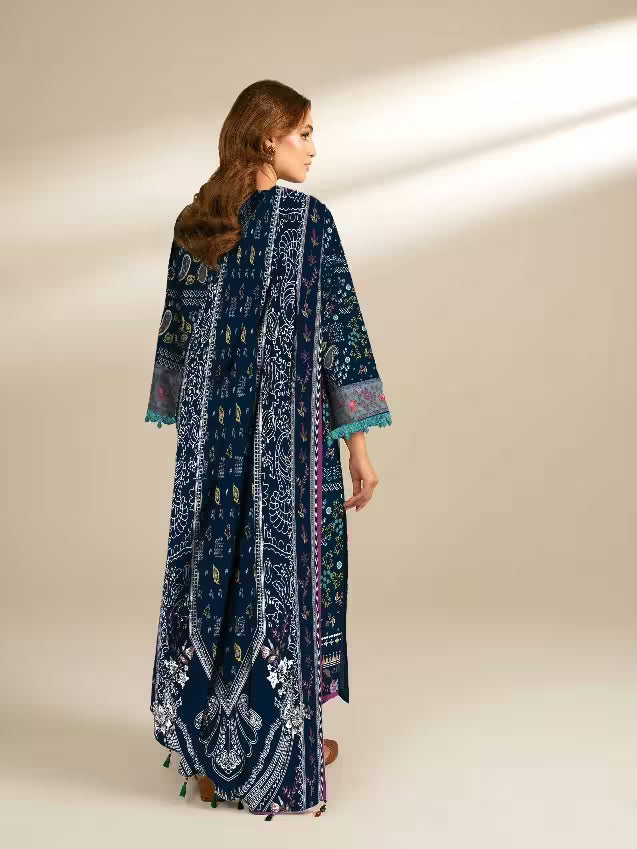 Woman wearing a long, dark blue embroidered dress with a pattern on a beige background