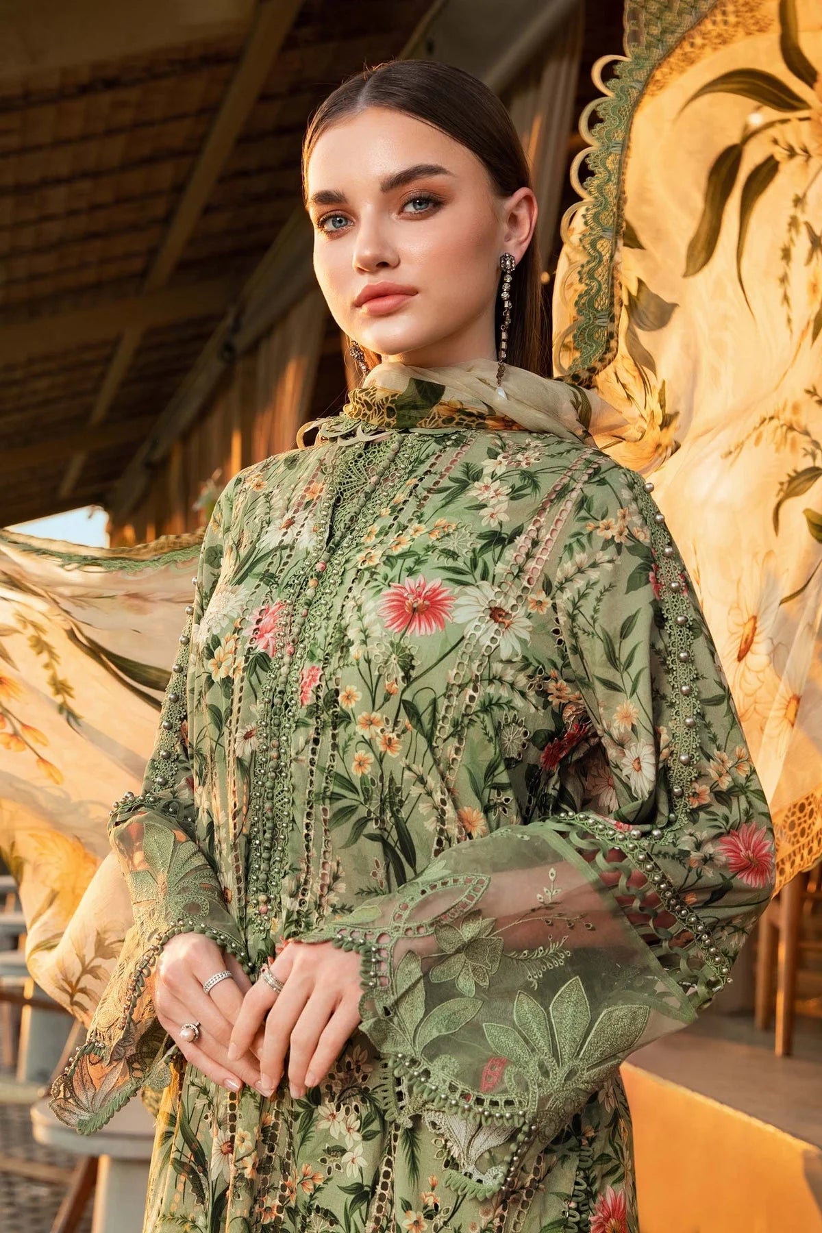 Woman wearing a green floral embroidered dress in an ornate setting