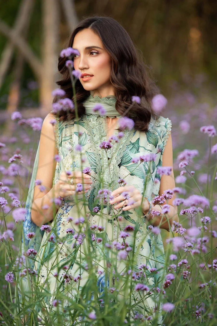 Woman in a green dress standing among purple flowers