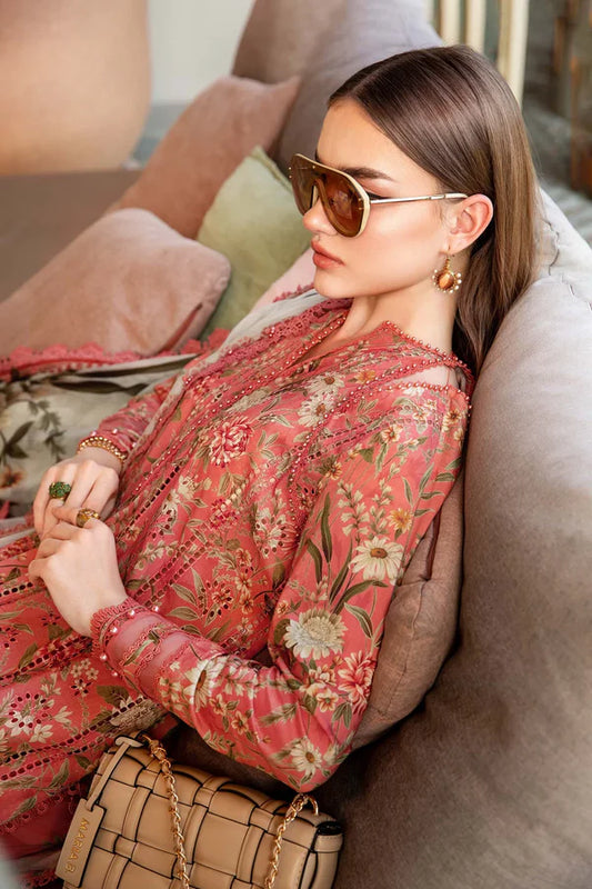 Woman in a floral dress sitting on a couch wearing sunglasses.