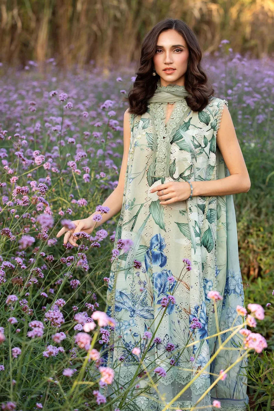Woman in a floral dress standing in a field of purple flowers