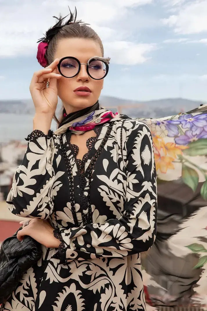 Woman wearing a black and white patterned dress with glasses outdoors.