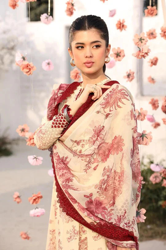 Woman wearing a floral saree with a red border against a floral background
